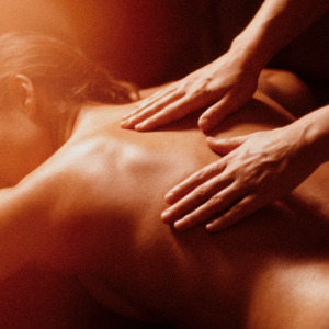 Massatge Californian Fusion a Nature Girona: mans expertes treballant l'esquena amb moviments fluids i llum càlida.